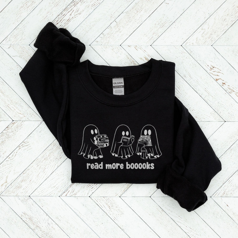 May include: Black sweatshirt with a white graphic of three ghosts reading books. The text "read more booooks" is printed below the ghosts.