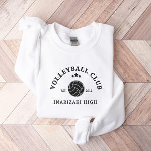 May include: White sweatshirt with black text that reads "Volleyball Club Est. 2012 Inarizaki High" and a black volleyball graphic.