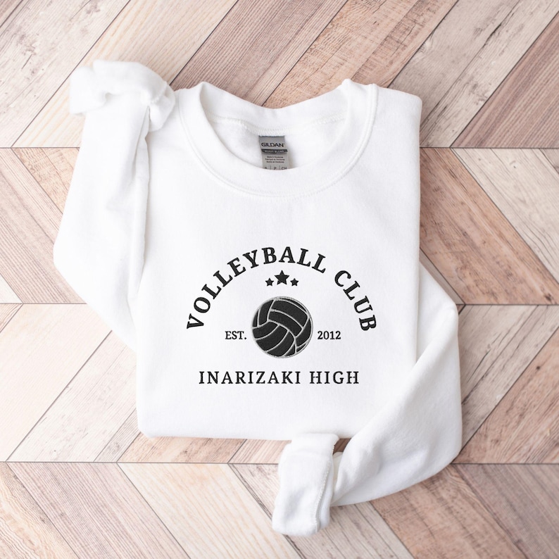 May include: White sweatshirt with black text that reads "Volleyball Club Est. 2012 Inarizaki High" and a black volleyball graphic.