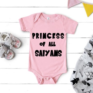 May include: Pink baby onesie with black text that reads "Princess of all Saiyans".