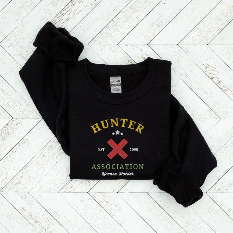 May include: Black sweatshirt with a yellow and red graphic that says "HUNTER ASSOCIATION License Holder" with a red X and the text "EST. 1998".