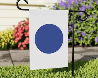 May include: A white garden flag with a large, solid blue circle in the center. The flag is attached to a black metal pole.
