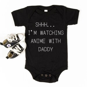 May include: Black baby onesie with white text that reads "SHHH... I'M WATCHING ANIME WITH DADDY".