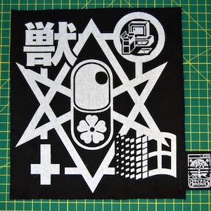 May include: Black and white patch with a geometric design featuring a star, a cross, a pill shape, and a building. The text "remark" is printed in white on the patch.