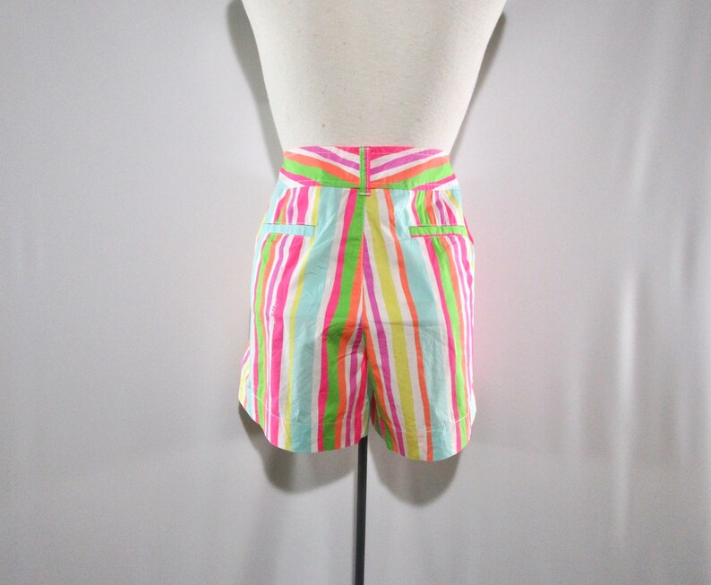 May include: Colorful striped shorts in shades of pink, green, yellow, and blue. The shorts have a high waist and pockets. The vertical stripes create a vibrant and playful look, perfect for warm weather.