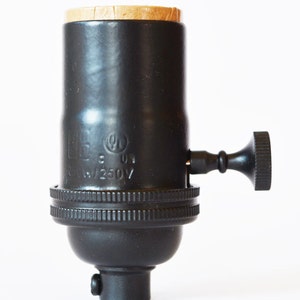 May include: Black metal light bulb socket with a side switch and a brown plastic cap. The socket is labeled "UL" and "125V".