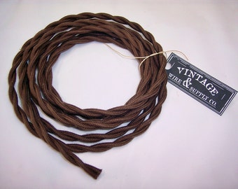 May include: Brown twisted cloth-covered electrical wire with a black and white tag that reads "Vintage Wire & Supply Co."