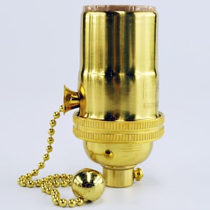 May include: A gold-toned light bulb socket with a pull chain. The socket is labeled "660V".
