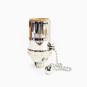 May include: A chrome light bulb socket with a pull chain. The socket has a threaded opening for a light bulb and a pull chain with a round metal ball at the end.