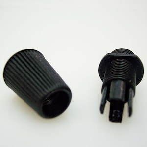 May include: Two black plastic electrical cord connectors. One connector has a threaded end and the other has a smooth, ribbed end.