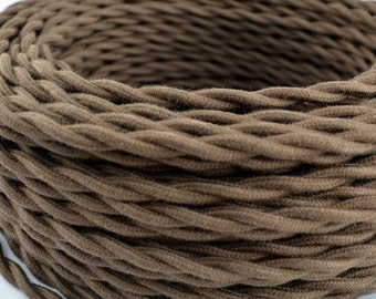 May include: Close-up of a spool of brown twisted electrical cord. The cord is made of a thick, textured fabric.
