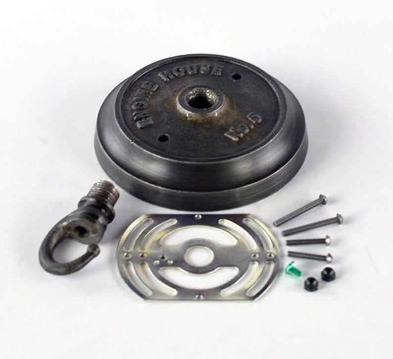 May include: A black metal ceiling fixture kit with a round base, a hook, a metal plate, and screws. The base has the text "EICHE HOUSE" and "120.15" on it.