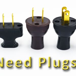 Puede incluir: Surtido de enchufes el&eacute;ctricos en varios estilos y colores, incluyendo negro, marr&oacute;n y amarillo. Los enchufes est&aacute;n dispuestos en una fila sobre una superficie blanca. El texto "Need Plugs?" est&aacute; escrito en amarillo debajo de los enchufes.