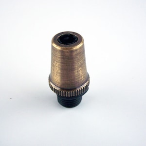 May include: A brass lamp socket with a black threaded base. The socket is designed to hold a light bulb.