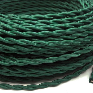 May include: A spool of dark green twisted electrical cord. The cord is made of fabric and has a two-pin plug.