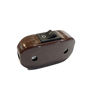 May include: A brown plastic inline switch with a black rocker switch. The switch has two screw terminals and is labeled "CE Certified".