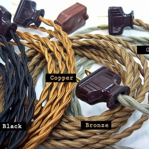 May include: Close-up of several electrical cords with plugs in various colors: black, copper, bronze, and gray. The cords are twisted and have a vintage aesthetic. The plugs are brown.