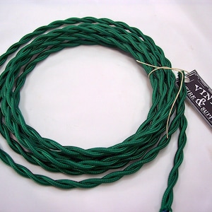 May include: A spool of green twisted electrical wire with a black and white tag that reads "Vintage & Supply Co."