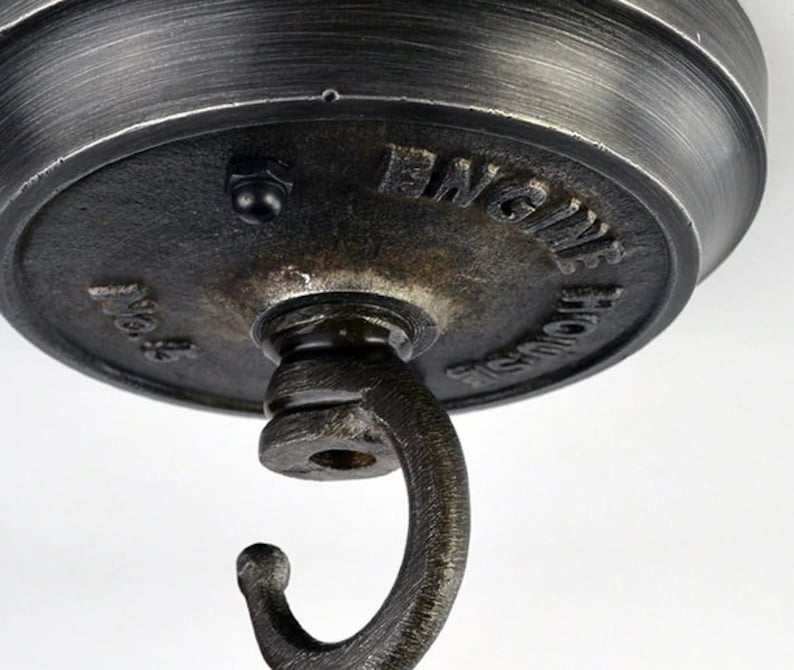 May include: A black metal ceiling hook with the words "Engine House" embossed on the top. The hook is designed for hanging light fixtures.