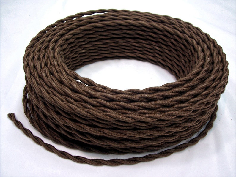 May include: A spool of brown twisted electrical cord. The cord is wound tightly and is ready to be used for electrical projects.