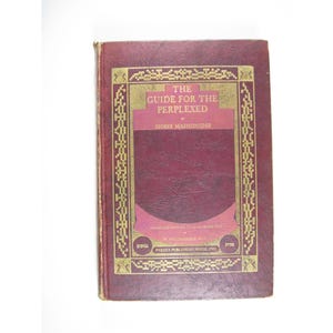 May include: A hardcover book titled The Guide for the Perplexed by Moses Maimonides, featuring a deep red textured cover with gold foil decorative borders and lettering. The front cover includes the text translated from the original Arabic text by M. Friedlander, Ph.D., and the publisher name Pardes Publishing House, Inc.