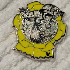 May include: A silver pin with a yellow enamel design. The pin features a cartoon image of Mickey Mouse dressed as a graduation cap. The pin has a Mickey Mouse head logo on the bottom.