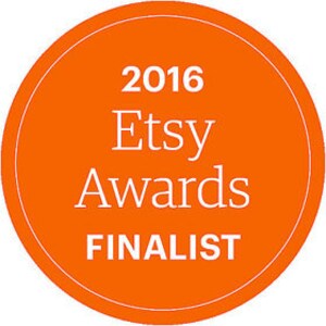 May include: Orange circle with white text that reads "2016 Etsy Awards FINALIST".