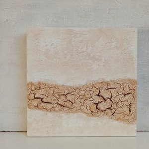 May include: Abstract painting on canvas with a textured, cracked brown line across the middle of the canvas. The background is a light beige color.