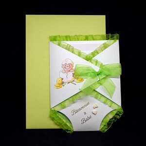 3D baby shower card in the shape of a green swaddle pattern baby in an egg and green ribbon