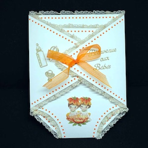 Carte de naissance jumeaux en 3D en forme de  lange blanche motif bébés jumeaux dans fleurs orange et dentelle orangée