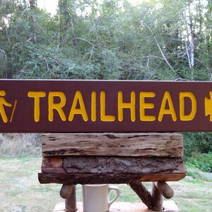 TRAILHEAD with hiker and arrowhead, park style path hiking trail cabin campground sign. Carved routed reflective lettering & symbols MA002+