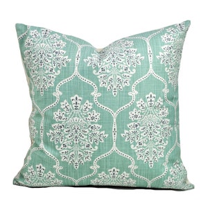 Pu&ograve; includere: Un cuscino quadrato decorativo con sfondo verde acqua chiaro e motivo floreale bianco e grigio scuro. Il cuscino ha un aspetto strutturato e un aspetto morbido e invitante, perfetto per aggiungere un tocco di eleganza a qualsiasi stanza.