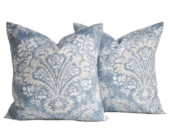 May include: Two blue and white patterned throw pillows with a floral design.
