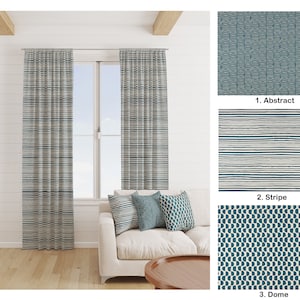 Peut inclure: Deux rideaux rayés bleus et blancs sont suspendus à une fenêtre dans une pièce avec un canapé blanc et une table basse en bois. Les rideaux sont faits d'un tissu doux et tissé. Le canapé a deux coussins à motifs bleus et blancs. La pièce a des murs blancs et un sol en bois.