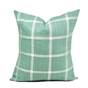 Pu&ograve; includere: Cuscino quadrato decorativo con motivo a quadri verdi e bianchi. Il cuscino presenta un classico motivo a griglia e una superficie morbida e strutturata. Ideale per aggiungere un tocco di stile a qualsiasi spazio.
