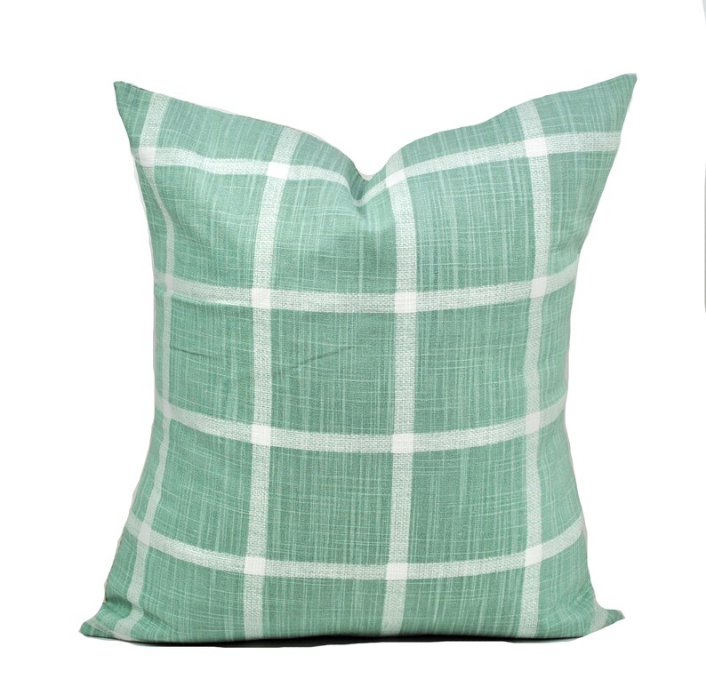 Pu&ograve; includere: Cuscino quadrato decorativo con motivo a quadri verdi e bianchi. Il cuscino presenta un classico motivo a griglia e una superficie morbida e strutturata. Ideale per aggiungere un tocco di stile a qualsiasi spazio.