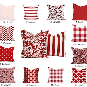 May include: Twelve red and white patterned throw pillows with numbers and names. The pillows are arranged in four rows of three pillows each.