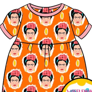 Puede incluir: Tela naranja con un patrón repetido de la cara de Frida Kahlo. La tela está diseñada para un vestido con mangas cortas y un ribete rosa. El texto "Wafflemama Fabric Design" está en un círculo amarillo.