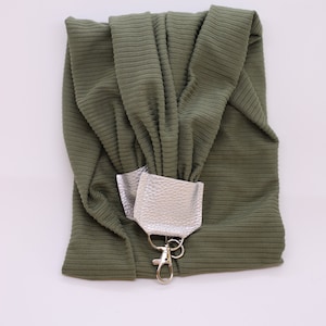 May include: A green fabric pouch with a silver leather strap and a silver metal hook.