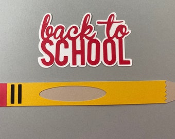 May include: Red paper cut-out with the words "back to school" and a yellow paper pencil with a red eraser and black stripes.