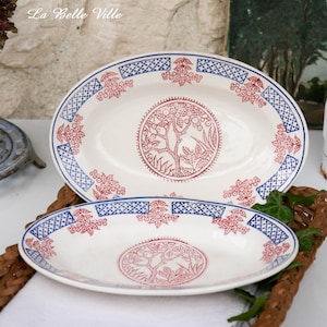 May include: Two oval ceramic serving platters with blue and red floral designs. The platters feature a central tree motif with red and white details. The text "La Belle Ville" is visible in the top left corner of the image.