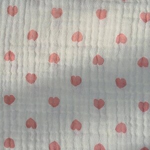 May include: White fabric with a pink heart pattern. The hearts are evenly spaced and are a light pink color.