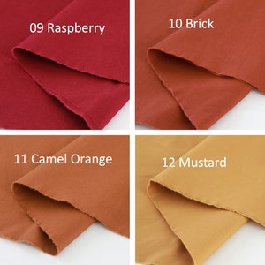 Puede incluir: Cuatro muestras de tela en tonos de rojo, naranja y amarillo. Las muestras est&aacute;n etiquetadas con nombres de colores y n&uacute;meros: 09 Frambuesa, 10 Ladrillo, 11 Naranja Camel y 12 Mostaza. Los bordes de la tela son crudos y sin terminar.