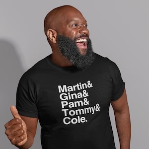 May include: A black t-shirt with white text that reads "Martin & Gina & Pam & Tommy & Cole."