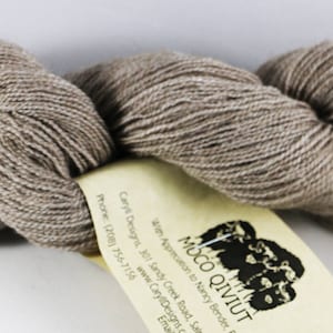 May include: A skein of light brown yarn with a label that reads "Eco Qiviut" and includes information about the yarn's origin and care instructions.