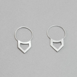 Pode incluir: Um par de brincos de argola de prata com um pingente geométrico triangular. O pingente tem um design recortado.