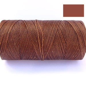 Op de afbeelding: Een spoel bruin gewaxt garen voor lederbewerking.