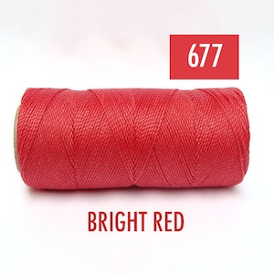 May include: A spool of bright red waxed thread, labeled "677 BRIGHT RED".