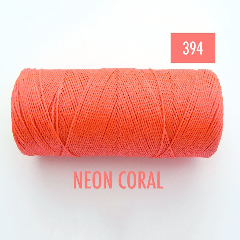 May include: A spool of neon coral colored thread. The spool is labeled with the number 394 and the words "NEON CORAL".