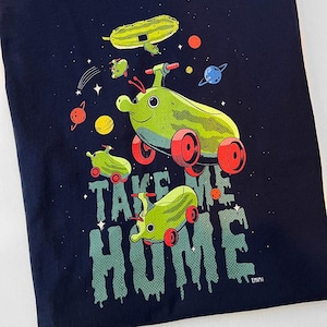 Peut inclure: T-shirt bleu marine avec un motif fantaisiste de sauteurs spatiaux verts avec des roues rouges et un th&egrave;me spatial. Le texte "TAKE ME HOME" est imprim&eacute; dans une police d&eacute;goulinante. Des plan&egrave;tes et des &eacute;toiles sont &eacute;galement incluses.